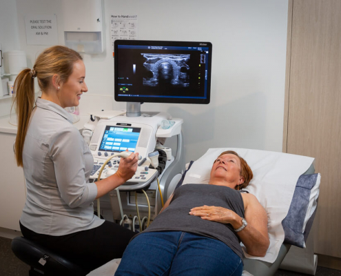 Women lying down next to a sonographer getting an ultrasound