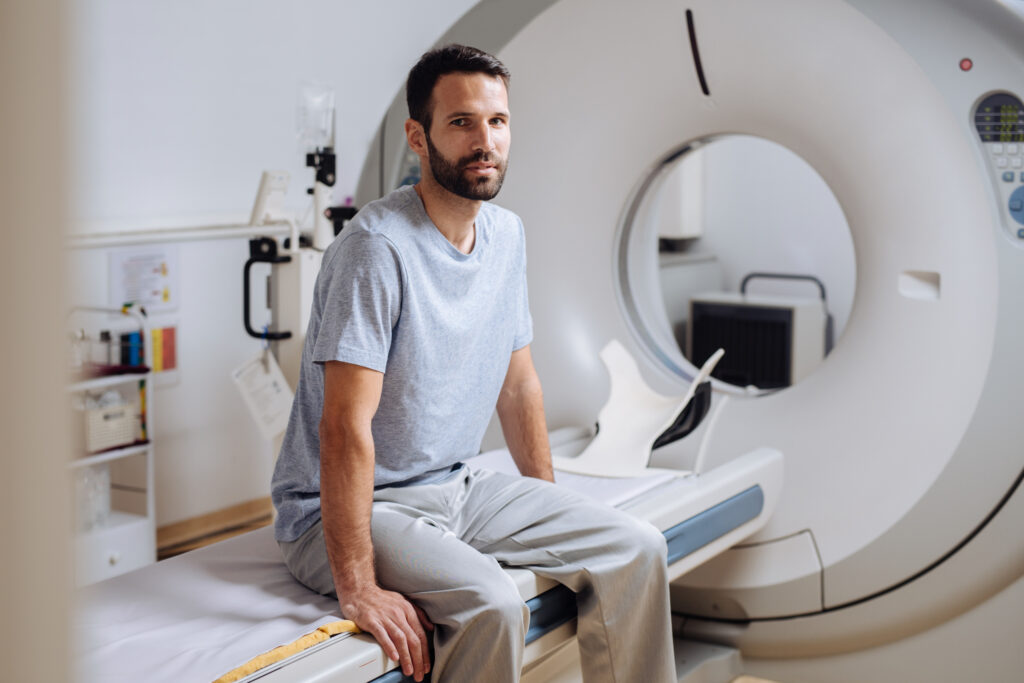 Patient sitting on CT table looking at the camera.
