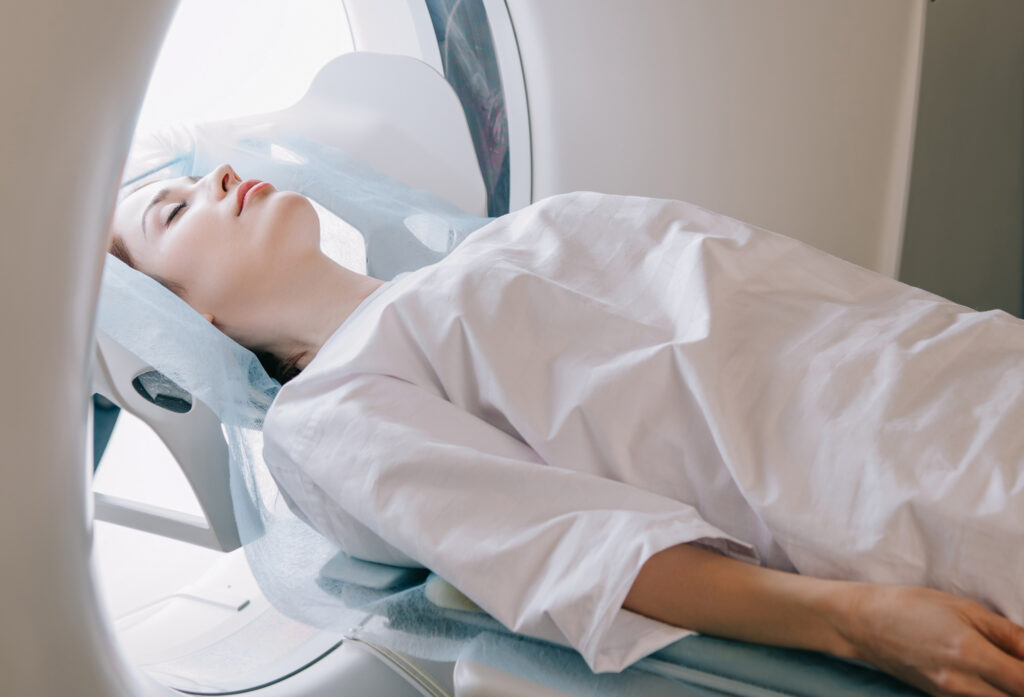 A patient lying on a medical imaging scanner table during a diagnostic scan.