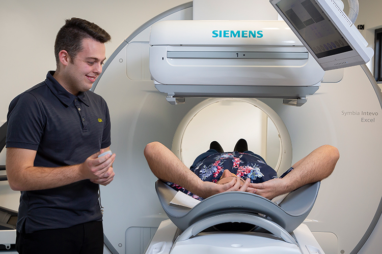 Nuclear medicine technologist preparing a patient for a SPECT-CT imaging scan.